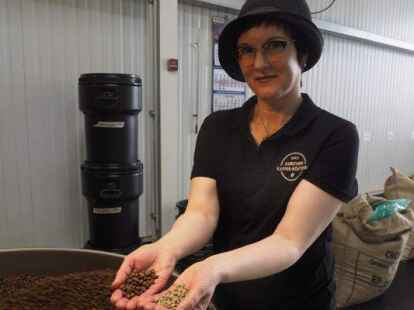 Sonja Lamb zeigt den Unterschied zwischen einer ger&ouml;steten und einer unger&ouml;steten Bohne. Kommen die Bohnen frisch ger&ouml;steten aus der Maschine verspr&uuml;hen sie allerdings noch keinen Kaffeegeruch. Dies geschieht erst, wenn sie etwas geruht haben.