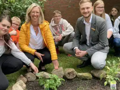 Jutta J&uuml;nemann von der Oldenburgischen Landesbank (Mitte links) und Florian D&uuml;ser von der LzO (Mitte rechts) mit Sch&uuml;lerinnen und Sch&uuml;lern der siebten Klassen vor dem Kr&auml;uterbeet.