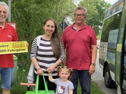 Die Ukrainerin Mariia Kharuna und ihre Tochter sind die Fahrg&auml;ste Nummer 150.000 und Nummer 150.001 beim B&uuml;rgerbus. Sie stiegen an der Haltestelle in Waddens in den von Volker Auffarth (rechts) gefahrenen Bus. Der Vereinsvorsitzende J&uuml;rgen Sprickerhof &uuml;berreichte einige Geschenke.