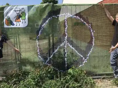 Auch Luisa und Keno, die Sch&uuml;lersprecher der Grundschule D&uuml;rerstra&szlig;e, freuen sich &uuml;ber das neue Friedensbanner.