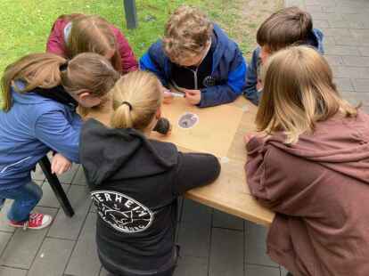Lilli (14), Milan (9), Patrick (10), Maja (13) und Lina (10) gestalten zusammen mit Tierpflegerin Sarah Kleinke (22, Mitte) ein Plakat zum Thema Hund.