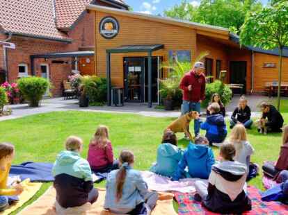 Tierheimleiter Dominic K&ouml;ppen (Mitte stehend) und sein neunj&auml;hriger Rhodesian Ridgeback Bailey zeigen, wie man sich einem Hund ann&auml;hert. Patrick (10, Mitte kniend) zeigt was es zuvor bei Antonia Heinze (Leitung Jugendtierschutz) gelernt hat.