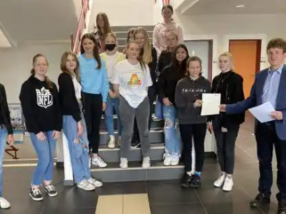 Sarina Rick (links) und Schulleiter Andreas Langen (rechts) mit 13 von 16 Sch&uuml;lerinnen, die die Ausbildung zur Schulsanit&auml;terin erfolgreich absolviert haben.