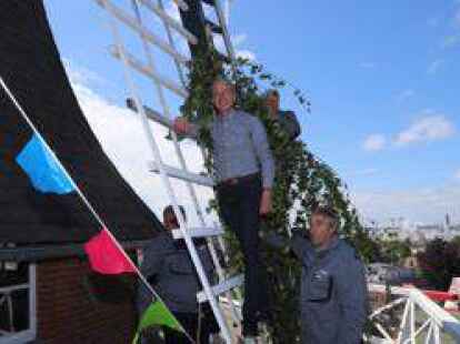 Raimund Recksiedler (vorne) und Peter Fleckenstein stiegen auf den M&uuml;hlenfl&uuml;gel, um ihn mit einem Birkenast zu schm&uuml;cken.