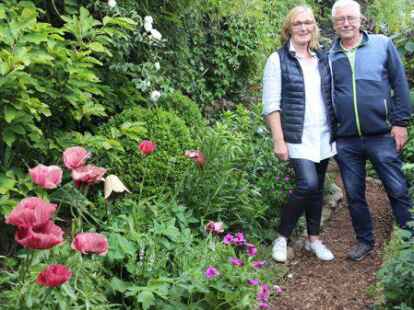 Elke Grape und Helmut Strodthoff haben hinter der bewachsenen L&auml;rmschutzwand einen &bdquo;Geheimen Garten&ldquo;, durch den sich ein Weg schl&auml;ngelt.