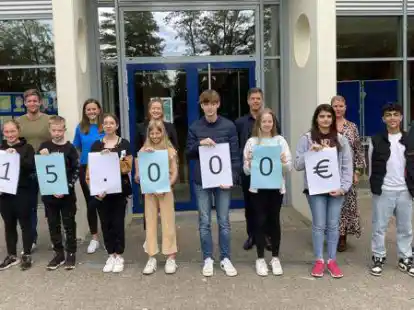 Sch&uuml;lerinnen und Sch&uuml;ler der Realschule Wildeshausen pr&auml;sentieren den Erl&ouml;s des Spendenlaufes. Im Hintergrund: (von links) Lehrer und Initiator Martin Wessel, die Sportlehrerinnen Julia B&uuml;nnemeyer und Leonie Rau, Bechtle-Gesch&auml;ftsf&uuml;hrer Michael S&uuml;&szlig;, Bechtle-Mitarbeiterin Insa S&uuml;&szlig; und Schulleiter Jan P&ouml;ssel.