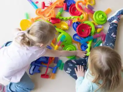 Zwei Kinder spielen in einem Kindergarten auf dem Fu&szlig;boden. Nach wochenlanger Corona-Zwangspause d&uuml;rfen Kinder nun wieder in die Krippen und Kitas. +++ dpa-Bildfunk +++