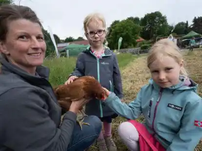 Wie f&uuml;hlen sich die Federn eines Huhns an? Angelika Reuter (von links) lie&szlig; Fenja (4) und Frieda (8) einmal streicheln.