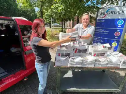 Bei der Flyer-&Uuml;bergabe (von links): Julia Schmidt aus der Flyer-Verteilgruppe verl&auml;dt mit Lars Kapscha von WE-Druck die frisch gedruckten 8000 Flugbl&auml;tter.