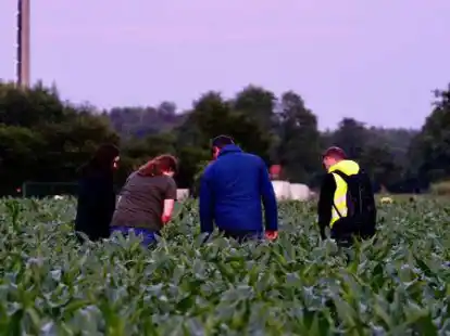 Pr&uuml;fender Blick: Zwei Mitarbeiter der Spurensicherung lassen sich von privaten Helfern die gefundenen Fu&szlig;spuren zeigen.