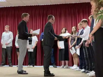 Zeugnis&uuml;bergabe durch Schulleiter Jan P&ouml;ssel (Mitte) und Sebastian T&ouml;njes, Klassenlehrer der 10a (links).
