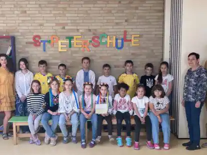 Bereit f&uuml;rs Benefizkonzert: Schulleiterin Elena Lietzmann, Choreografin Darina Bodnie (von links), der Kinderchor der St.-Peter-Schule Wildeshausen, Nina Honchrenko und Chor-Vorsitzender Uwe Leinemann (rechts).