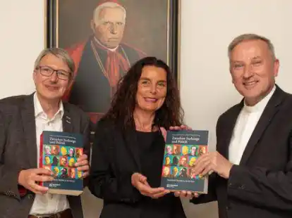 Prof. Dr. Michael Hirschfeld (von links) und PD Dr. Maria Anna Zumholz &uuml;berreichen Weihbischof Theising den neu aufgelegten Sammelband &bdquo;Zwischen Seelsorge und Politik. Katholische Bisch&ouml;fe in der NS-Zeit&ldquo;.