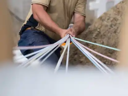 Ein Mitarbeiter einer Erdbaufirma b&uuml;ndelt Leerrohre f&uuml;r Glasfaser (Symbolbild): Schnelles und leistungsf&auml;higes Internet k&ouml;nnen nun auch Haushalte und Gewerbebetriebe in Augustfehn II erhalten.