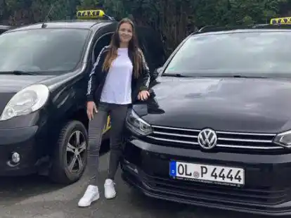 Fahrerin der Wildeshauser Taxen, Jennifer Boron, steht vor den Autos des Unternehmens.