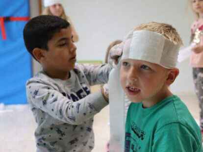 Mohammed und Cedric (beide sechs Jahre alt) &uuml;ben im Kindergarten Piccolino das Anlegen eines Verbandes.