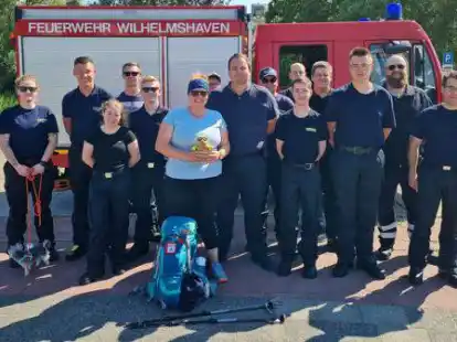 Stolz und gl&uuml;cklich hat Jaqueline Lubina (Mitte) nach 100 Kilometern das Ziel ihrer Spenden-Wanderung erreicht. Auf den letzten drei Kilometern ihrer Wanderung wurde sie von den Kameraden der Ortsfeuerwehren R&uuml;stringen und Bant-Heppens um Sebastian Grannemann (rechts neben ihr) begleitet.