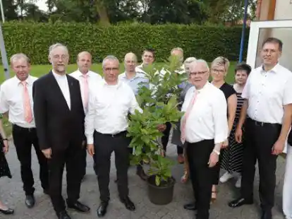 Von der Kolpingfamilie Bar&szlig;el &uuml;berreichte Vorsitzender Hans Geesen (5.v.r.) ein Eiche an den Str&uuml;cklinger Vorsitzenden Hans-Dieter Hanekamp (5.v.l.).