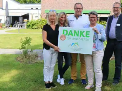 Uschi Nattke, Andrea Frerichs und Andreas Freiheit vom Organisationsteam der Rot-Blauen Nacht, Vorsitzende der Hospizbewegung Varel Anke K&uuml;ck und Stellvertretender Leiter des Hospiz am Wattenmeer Christian Winkel bei der Spenden&uuml;bergabe im Garten des Hauses der Hospiz- und Palliativarbeit &bdquo;Am Jadebusen&ldquo;.