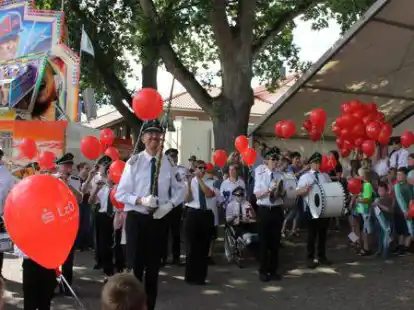 Bunte Szenerie beim vorerst letzten Kindersch&uuml;tzenfest 2019: Der Wardenburger Spielmannszug mit roten Luftballon auf dem Festplatz.
