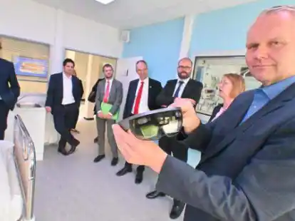 Der s&auml;chsische Kultusminister Christian Piwarz (3. v. r.) und der nieders&auml;chsische Wissenschaftsminister Bj&ouml;rn Th&uuml;mler (rechts) lie&szlig;en sich im An-Institut OFFIS vom Vorstand  erkl&auml;ren, wie eine &bdquo;Augmented-Reality-Brille&ldquo; in der Pflege helfen kann. Mit dabei war auch der Universit&auml;tspr&auml;sident der Universit&auml;t Oldenburg Prof. Dr. Ralph Bruder (4. v. r.).