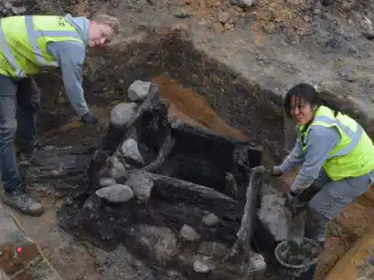 Einen gesch&auml;tzt rund 1000 Jahre alten Holzkasten-Brunnen haben die Mitarbeiter der Vechtaer Fachfirma &bdquo;Denkmal 3D&ldquo; &ndash; hier Tilman Bronner und Shan Ti Tsai &ndash; auf der s&uuml;dlichen Seite des Kirchhofs gefunden.