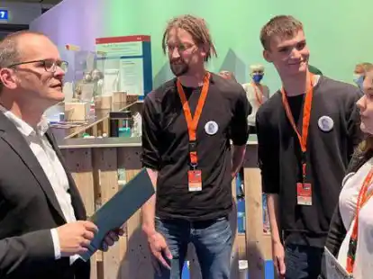 An ihrem Stand auf der &bdquo;IdeenExpo&ldquo; zeichnete Kultusminister Grant Hendrik Tonne (links) die Sch&uuml;lerfirma aus. Dar&uuml;ber freuten sich (von rechts) Joleen Schenk und Lukas Rademacher mit ihrem Lehrer Sven Kontek.