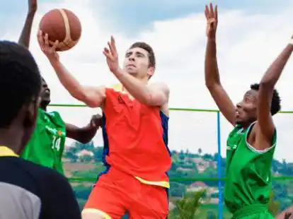 Ab durch die Mitte: Adrian Breitlauch (Mitte) beim Basketball spielen in Ruanda