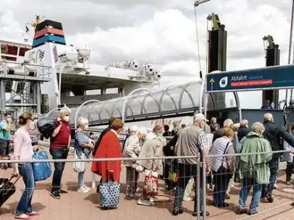 Touristen warten mit ihrem Gep&auml;ck am Frisia-F&auml;hrterminal in Norddeich, um auf die Insel Norderney zu fahren.
