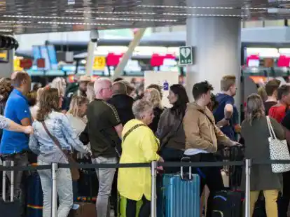 Reisende stehen in der Abflughalle  Schlange. Am niederl&auml;ndischen Flughafen Schiphol ist Chaos in diesem Sommer fast Alltag.