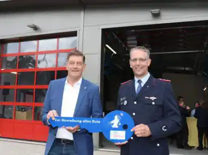 B&uuml;rgermeister Christoph Reents &uuml;bergibt Ortsbrandmeister Stefan Buschmann den symbolischen Schl&uuml;ssel f&uuml;r den neuen Anbau ans Wardenburger Feuerwehrger&auml;tehaus.
