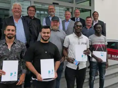 Gro&szlig;e Freude &uuml;ber die Zeugnisse: Ahmar Kengo, Taufik Moufak, Musa Swaray und Salimo Manneh (vorne von links) nach dem erfolgreichen Einstiegsjahr des &bdquo;Projekt 2+&ldquo;, dahinter (v.li.): Mathias Suhr, Jann Onneken, Rainer Beermann (unten), Heiko Henke, Heiko Posegga, Gert Mora Motta, Eduard Drefs und Kai Vensler.