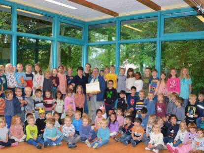 Spenden&uuml;bergabe inmitten von Kindern: Kitaleiterin Sabine Schneider &uuml;bergab den symbolischen Spendencheck an Louisa Blank (Vereinsvorsitzende) und Reinhold Weerts vom Verein &bdquo;Humanit&auml;re Soforthilfe Ammerland Ostfriesland&ldquo;.