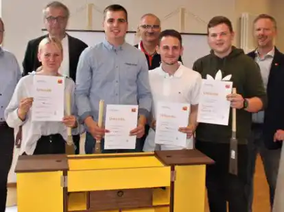 Die Campingbox aus Nussbaum gewinnt in der Sonderwertung &bdquo;Die gute Form&ldquo;: (v.l.): Johannes Ropke, Pauline Schulz (3. Platz), Hergen Garrelts, Simon Lobmeyer (1. Platz), Bernd Ahlers, Louis Enste (2. Platz), Lukas Siegert (Bestes Gesellenst&uuml;ck) und Elmar Schmidt bei der Ausstellung der Gesellenst&uuml;cke in der BBS Rostrup.