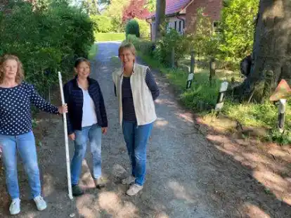 Der Stab markiert die Grundst&uuml;cksgrenze nach links: Der Sielweg ist aus Sicht von (v.l.) Antje Heinemann-Sanders, Liesel Heinemann und Ilona Schmietenknop viel zu schmal f&uuml;rs Reiten.
