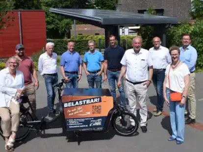 Freuten sich &uuml;ber die Installation des Solar-Bikeports (im Hintergrund) an der BBS Friesoythe am Standort Scheefenkamp (von links): Schulleiterin Marlies Bornhorst-Paul, Florian Frerichs, Heinrich K&uuml;hling, Carsten Vaske, Jens Rolfes, Matthias Plaggenborg, Bernhard M&ouml;ller, Michael Kramer, Petra Nienaber und Jan Roter.