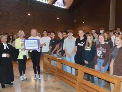 Beim Schul-Abschlussgottesdienst &uuml;berreichten die Religionslehrerinnen Nicole Hempen (von rechts) und Barbara Timmen einen symbolischen Scheck &uuml;ber 4200 Euro an Pastor J&uuml;rgen Schwartz.