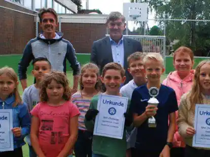 Die Grundschule Oestringfelde freut sich &uuml;ber den neuen Soccer Court. Schulleiter Stephan Immega (links) und B&uuml;rgermeister Gerhard B&ouml;hling er&ouml;ffneten den Platz jetzt zusammen mit einigen Sch&uuml;lern.