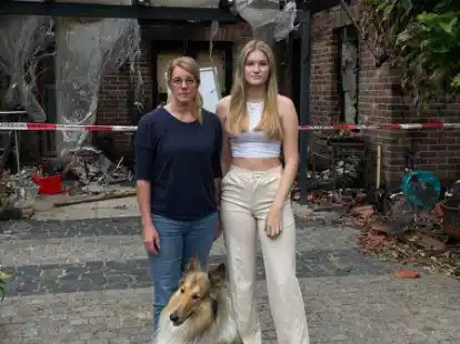 Vor ihrem vom Brand v&ouml;llig zerst&ouml;rten Haus in Kayhauserfeld: Andrea Holzenkamp und ihre Tochter Johanna mit Collie-Dame Holly. Sie suchen nun dringend eine neue Bleibe.