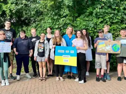 Die Migrationsberaterin Antje Hinrichs (9. von links) bekam von den Sch&uuml;lerinnen und Sch&uuml;lern die Spende &uuml;berreicht.