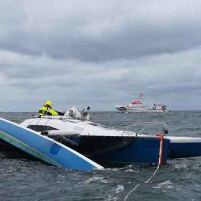 Havarierter Trimaran an der Schleppleine des Seenotrettungsbootes WOLFGANG PAUL LORENZ. Im Hintergrund die HERMANN MARWEDE