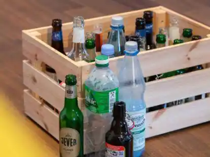 Verschiedene Pfandflaschen stehen vor und in einer Kiste auf dem Boden. Brauereien in der Region geht das Leergut aus. Sie rufen dazu auf, leere Mehrweg-Pfandflaschen zur&uuml;ckzubringen.