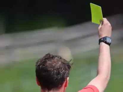 Ein Schiedsrichter zeigt eine Gelbe Karte. Wie oft das den Mannschaften widerf&auml;hrt, ist h&ouml;chst unterschiedlich.