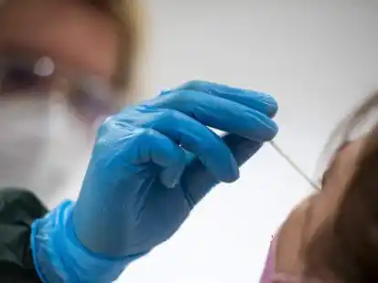 Eine Frau wird in einem Testzentrum auf das Coronavirus getestet. +++ dpa-Bildfunk +++