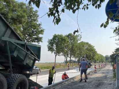 Eine Stra&szlig;enh&auml;lfte ist bereits asphaltiert, die n&auml;chste wird gerade geschottert: Bauarbeiten auf der Uphuser Stra&szlig;e zwischen Zanderstra&szlig;e und Osterh&ouml;rn. Der gesamte Gehweg muss noch gepflastert werden.