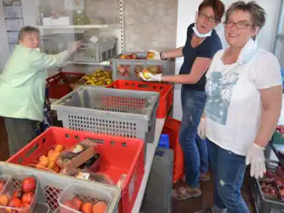 Arbeiten schon ewig zusammen: Elke Stillahn und Elke Meiners im Obststand der Wiegboldsburer Tafel mit einer Stammkundin.