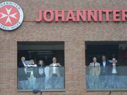 Auf dem Balkon einer Wohnung in der &bdquo;Neue Mitte Petersfehn&ldquo; (von links): Dienststellenleiter Stephan Siemer, Ines F&uuml;ssel vom Bereich Wohnkonzepte, die Leiterin der Stabsstelle Integration Helene Frieden, das designierte Mitglied im Regionalvorstand Dieter Meyer, JUH-Pr&auml;sident Volker Bescht, Ortsbeauftragter Lars Johnsen und Wilfried Barysch, Mitglied im Regionalvorstand.