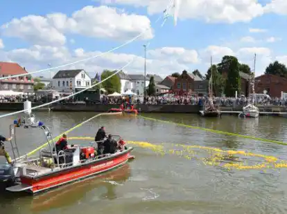 Ein Mehrzweckboot der Feuerwehr trieb die gelben Rennenten vor sich her.