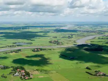 Wolken ziehen &uuml;ber die Ems in Landkreis Leer: Ackerbau spielt in Ostfriesland gegen&uuml;ber der Gr&uuml;nland-Nutzung eine untergeordnete Rolle, trotzdem finden in diesem Bereich durch Klimawandel und gesetzliche Vorgaben aktuell viele Ver&auml;nderungen statt.