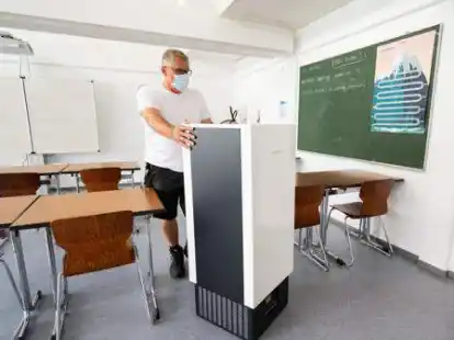 Ein Luftfilter wird in einen Klassenraum der Integrierten Gesamtschule Lehrte (Region Hannover) geschoben. Doch l&auml;ngst nicht alle Schulen sind so f&uuml;r den dritten Corona-Herbst ausger&uuml;stet.
